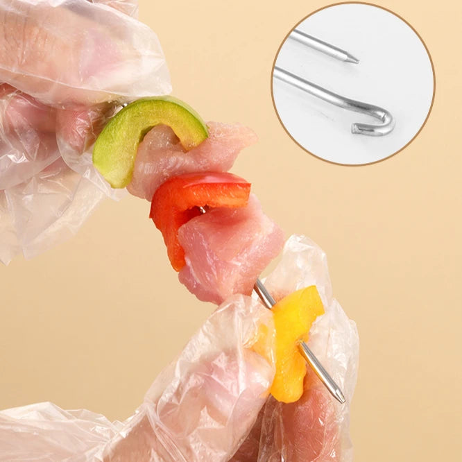 Person skewering meat and vegetables with a metal skewer