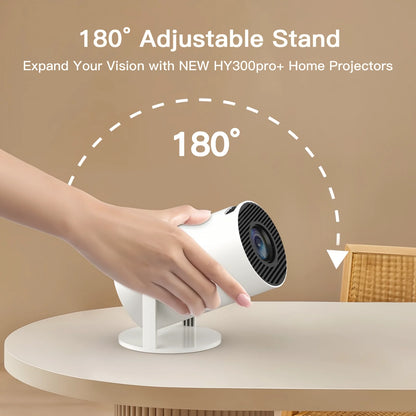Hand adjusting a white projector on a beige surface with text about 180-degree adjustable stand.