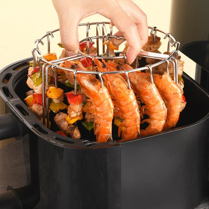 Shrimp and vegetables being added to an air fryer basket.