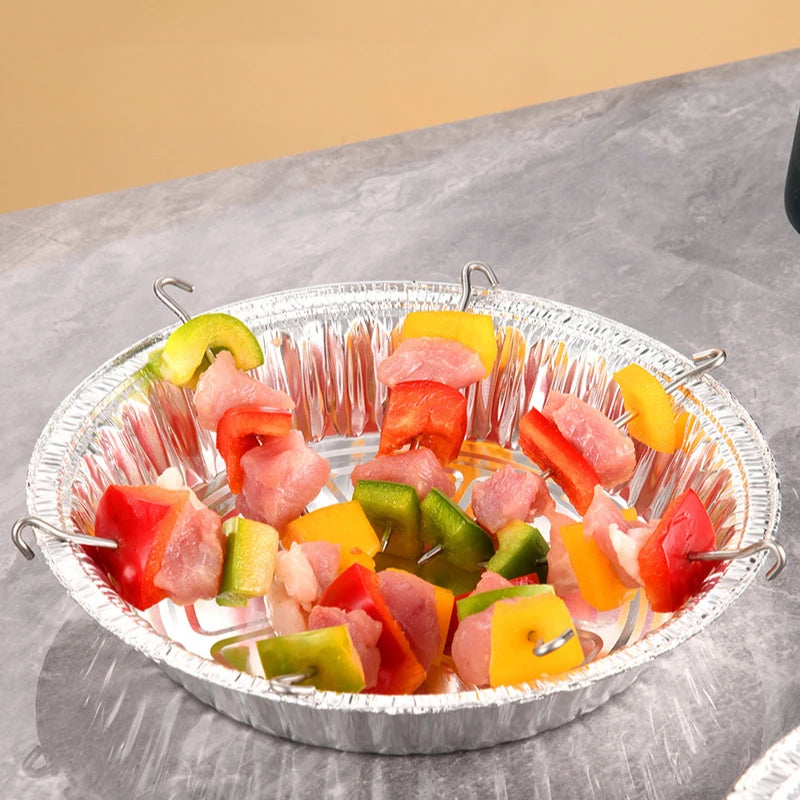 Skewers of colorful vegetables and meat in a foil pan.